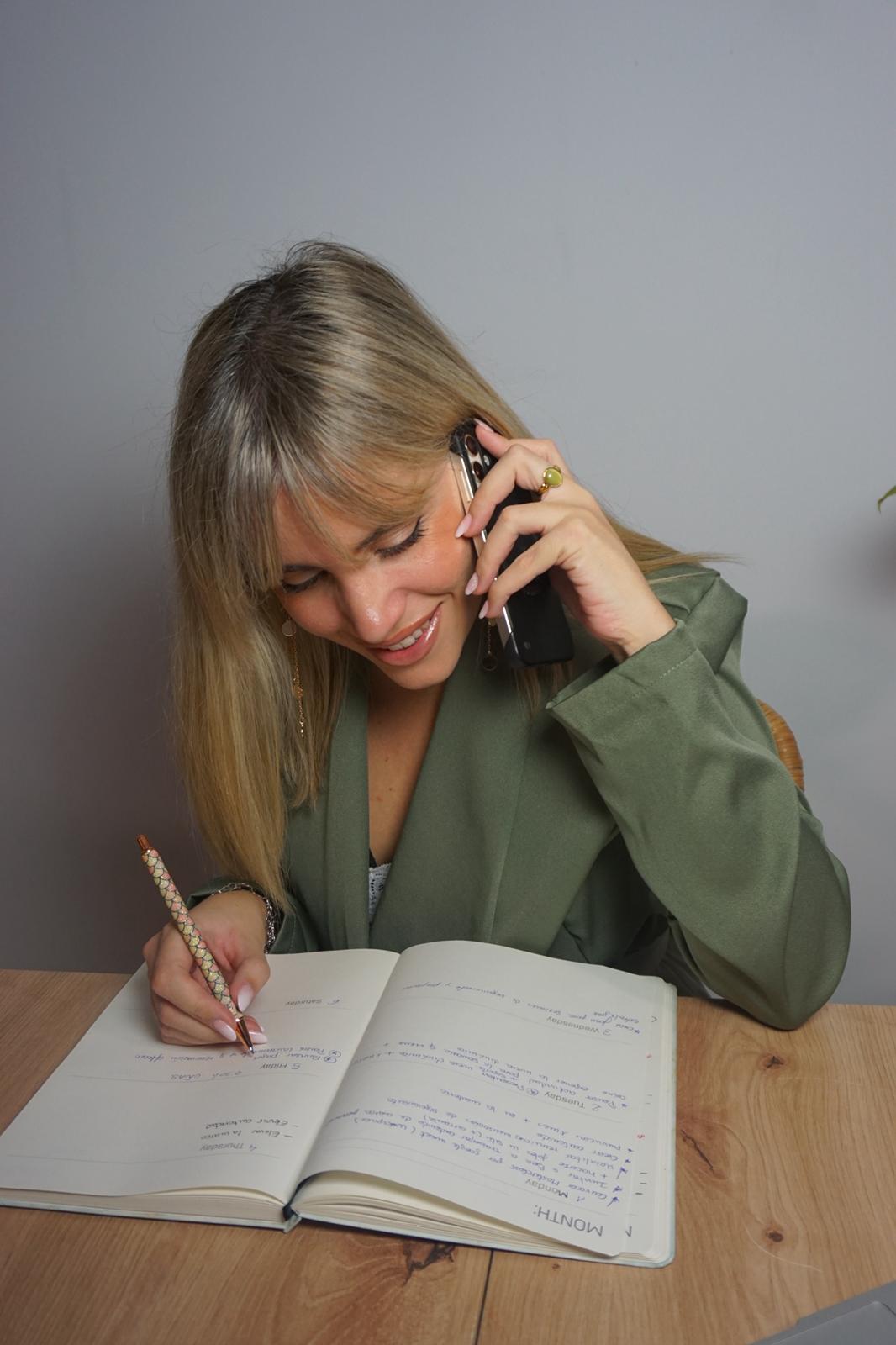 Gemma Ojeda hablando por teléfono mientras toma notas en su cuaderno